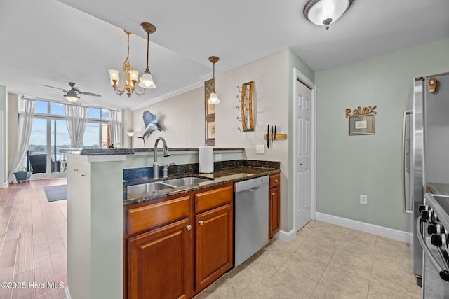 kitchen featuring sink, dark stone counters, hanging light fixtures, kitchen peninsula, and stainless steel appliances