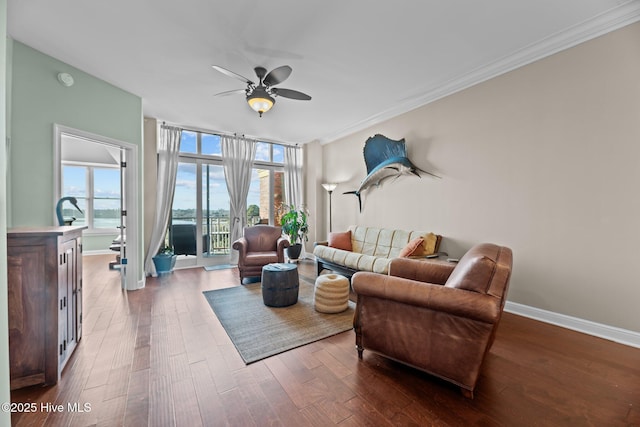 living room with crown molding, wood-type flooring, floor to ceiling windows, and ceiling fan