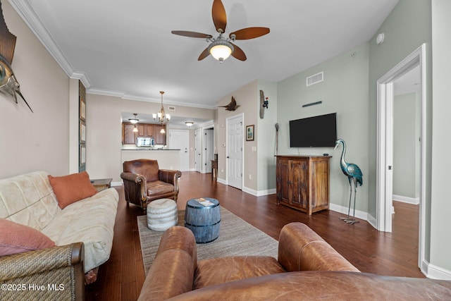 living room featuring crown molding, dark hardwood / wood-style flooring, and ceiling fan with notable chandelier