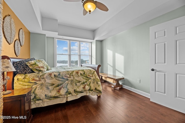 bedroom with dark hardwood / wood-style flooring and ceiling fan