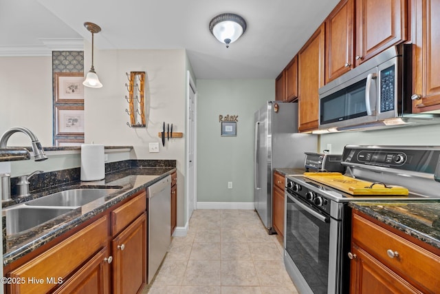 kitchen with pendant lighting, sink, light tile patterned floors, dark stone countertops, and stainless steel appliances