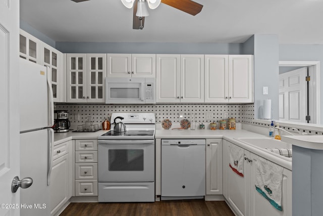 kitchen featuring dark hardwood / wood-style flooring, backsplash, white appliances, and white cabinets