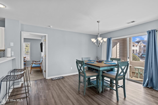 dining space with an inviting chandelier and dark hardwood / wood-style floors