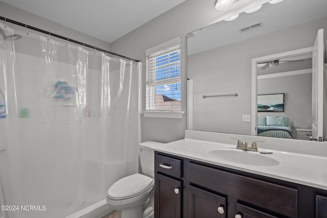 bathroom featuring vanity, walk in shower, and toilet