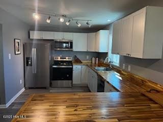 kitchen featuring appliances with stainless steel finishes, sink, hardwood / wood-style floors, and white cabinets