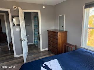 bedroom with dark hardwood / wood-style floors and a closet