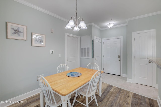 dining space featuring baseboards, visible vents, crown molding, and wood finished floors