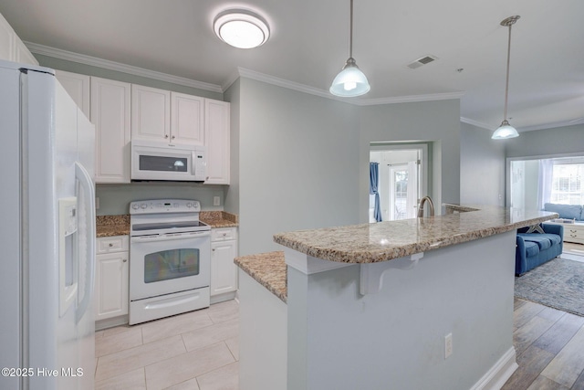 kitchen featuring white appliances, white cabinets, a breakfast bar area, decorative light fixtures, and crown molding