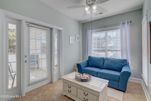 living room with a ceiling fan, light tile patterned flooring, visible vents, and a healthy amount of sunlight