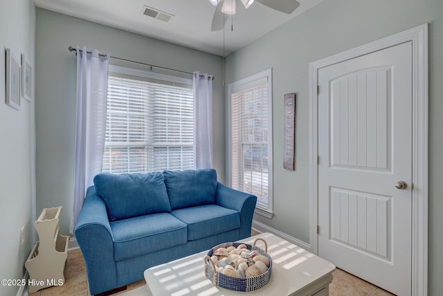 living room with ceiling fan, visible vents, and baseboards