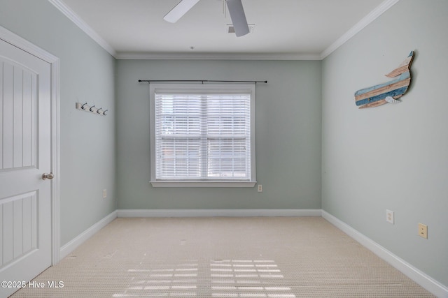 empty room with ornamental molding, ceiling fan, and baseboards