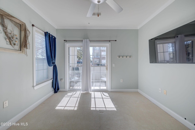 spare room with ornamental molding, a wealth of natural light, and baseboards