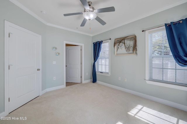 unfurnished bedroom with carpet floors, baseboards, ornamental molding, and ceiling fan