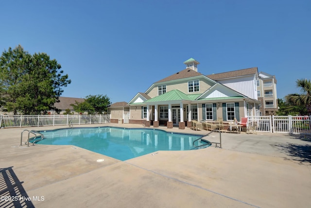 community pool with fence and a patio