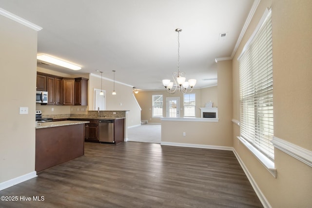 kitchen featuring pendant lighting, stainless steel appliances, crown molding, dark wood-type flooring, and an inviting chandelier