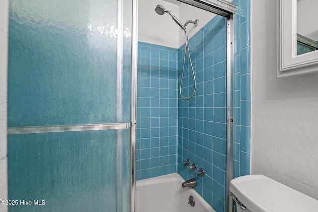 bathroom featuring toilet and tiled shower / bath combo