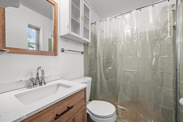 bathroom with a shower with curtain, vanity, toilet, and a textured ceiling