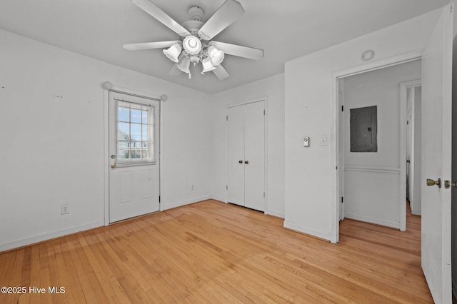 spare room featuring electric panel, light hardwood / wood-style floors, and ceiling fan