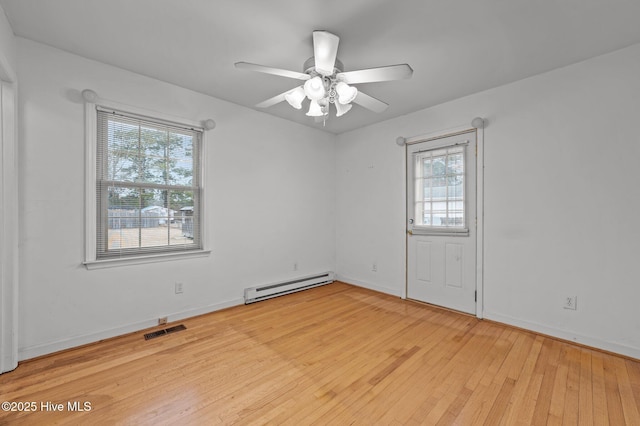 empty room featuring ceiling fan, a baseboard heating unit, and light wood-type flooring