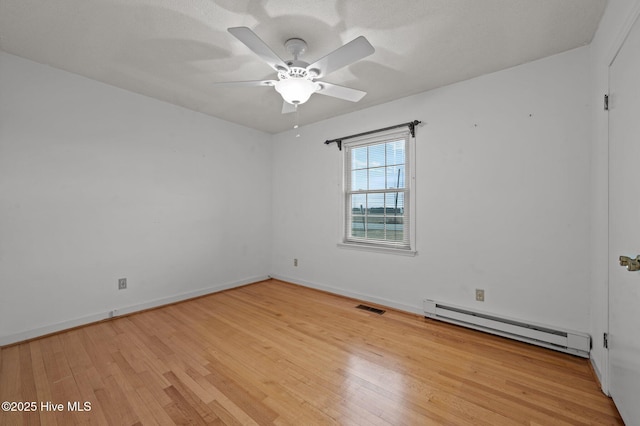 unfurnished room featuring a baseboard heating unit, light hardwood / wood-style flooring, and ceiling fan