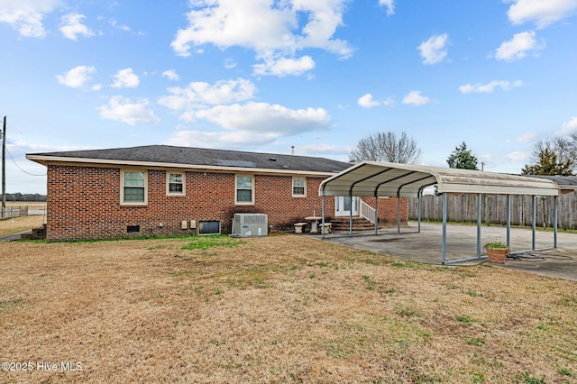 rear view of property with a yard, a carport, and central air condition unit