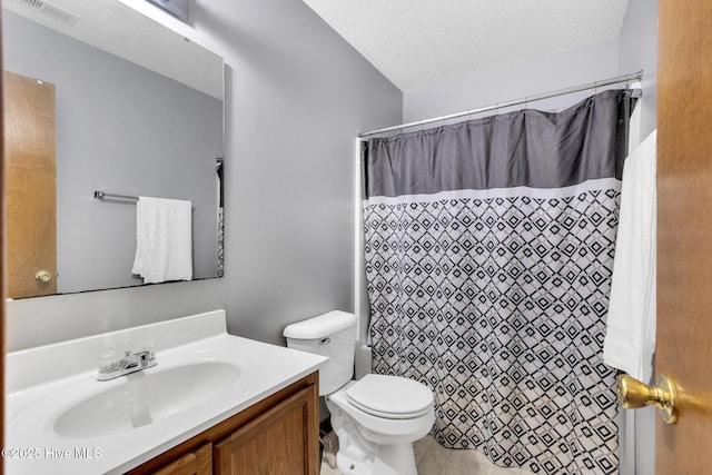 bathroom with vanity, toilet, a textured ceiling, and walk in shower