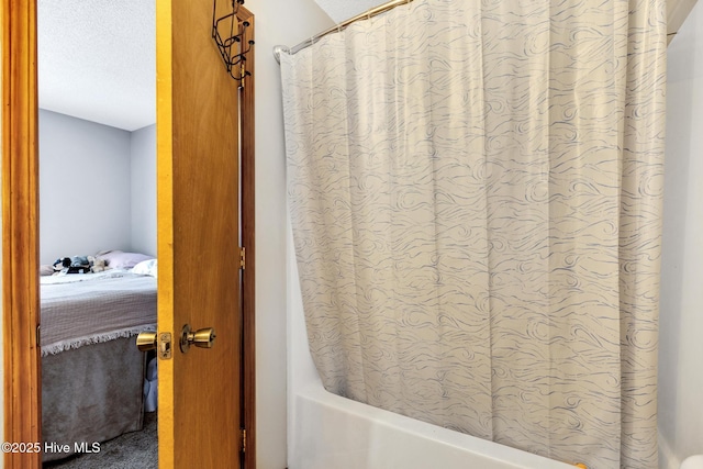 bathroom with shower / tub combo and a textured ceiling