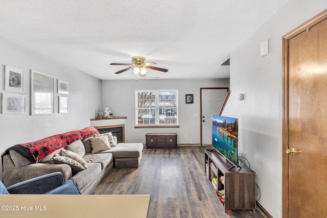 living room with ceiling fan, dark hardwood / wood-style floors, and a textured ceiling