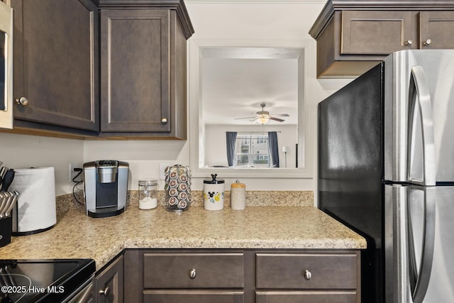 kitchen featuring dark brown cabinets, stainless steel fridge, and ceiling fan