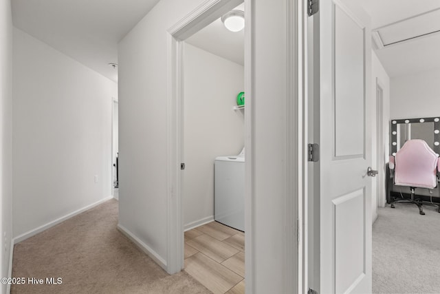 corridor featuring washer / dryer and light colored carpet