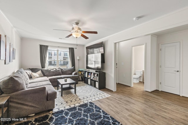 living room with ornamental molding, hardwood / wood-style floors, and ceiling fan