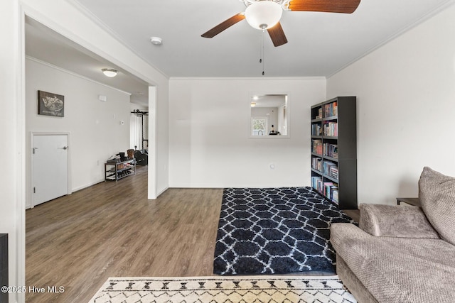 living room featuring hardwood / wood-style flooring, crown molding, and ceiling fan