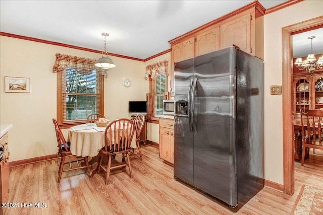 kitchen with stainless steel appliances, pendant lighting, and light hardwood / wood-style flooring