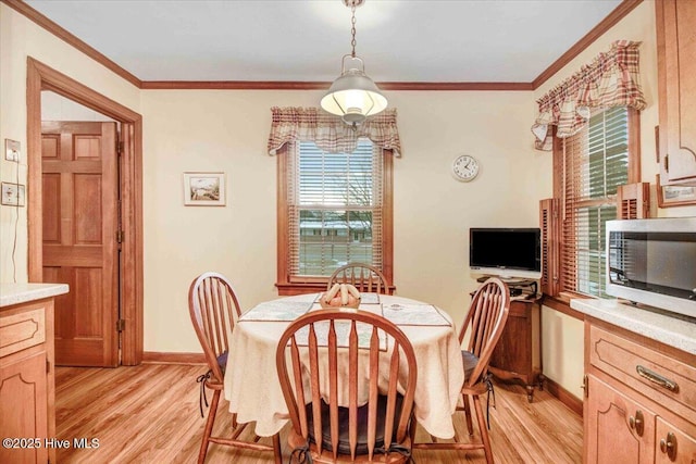 dining space with crown molding and light wood-type flooring