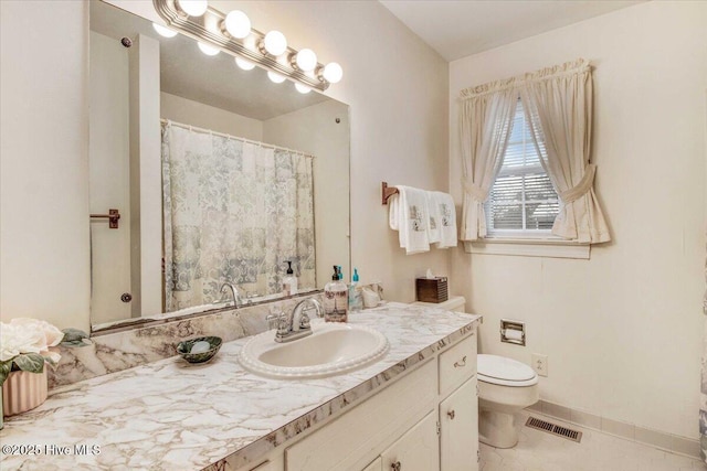 bathroom with tile patterned flooring, vanity, and toilet