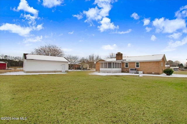 back of house featuring a yard and a sunroom