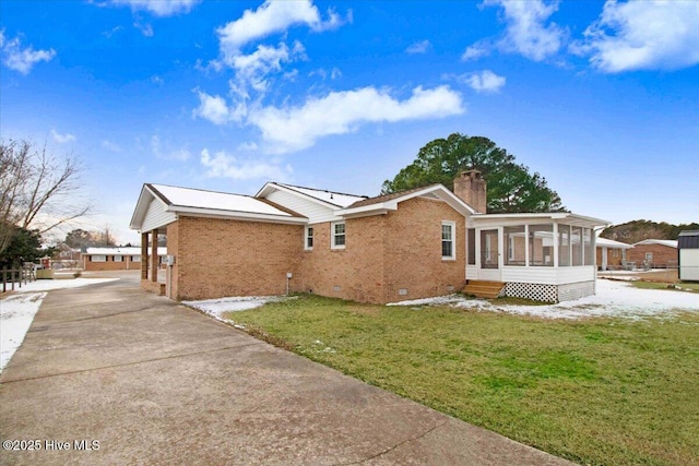 back of property with a yard and a sunroom