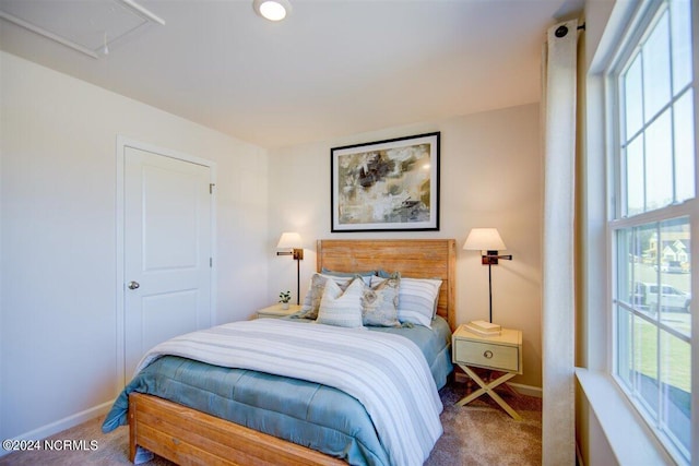 bedroom with attic access, carpet flooring, and baseboards