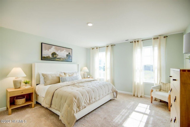 bedroom featuring baseboards and light colored carpet