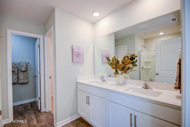 bathroom featuring vanity, wood-type flooring, and a shower with door