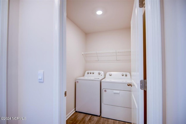 washroom with washing machine and dryer, laundry area, and wood finished floors