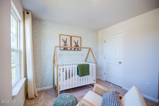 bedroom with a nursery area and carpet