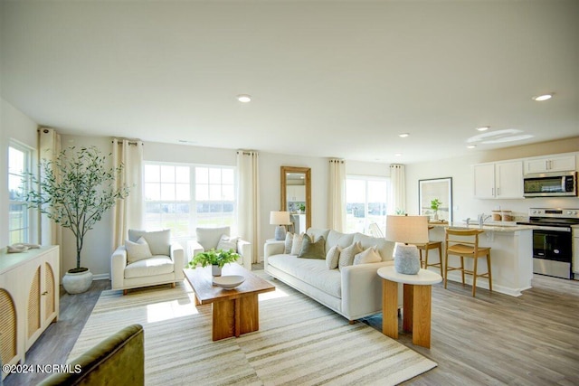 living room featuring light wood-style flooring and recessed lighting