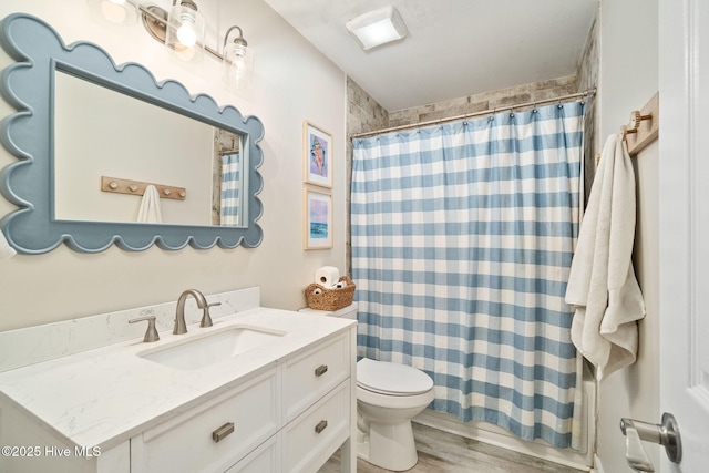 bathroom featuring vanity, hardwood / wood-style floors, walk in shower, and toilet