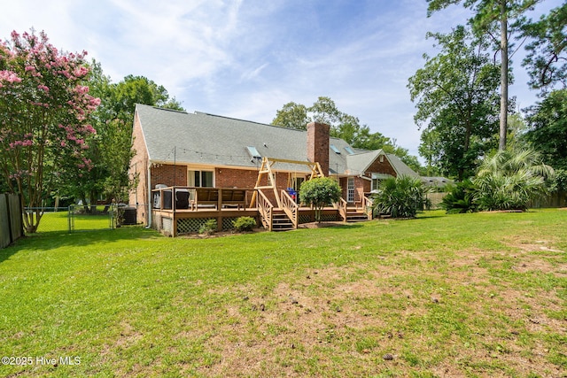 back of property with a wooden deck and a lawn