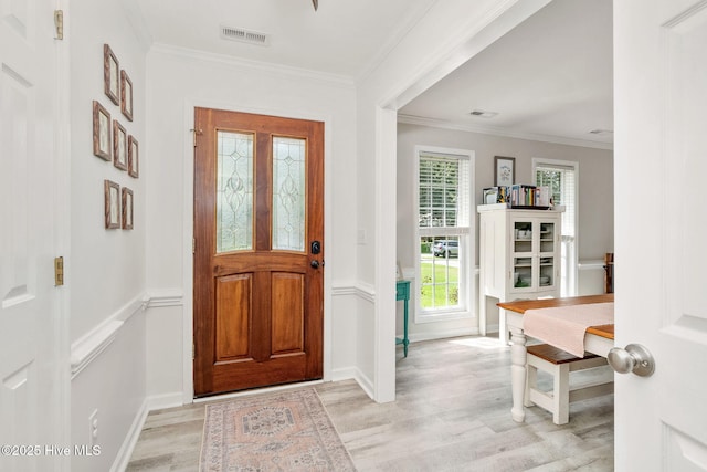 entryway with crown molding and light wood-type flooring