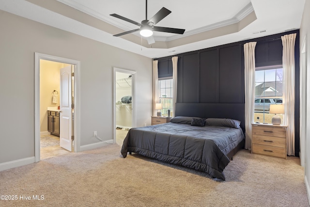 carpeted bedroom with ensuite bathroom, a spacious closet, a tray ceiling, a closet, and ceiling fan