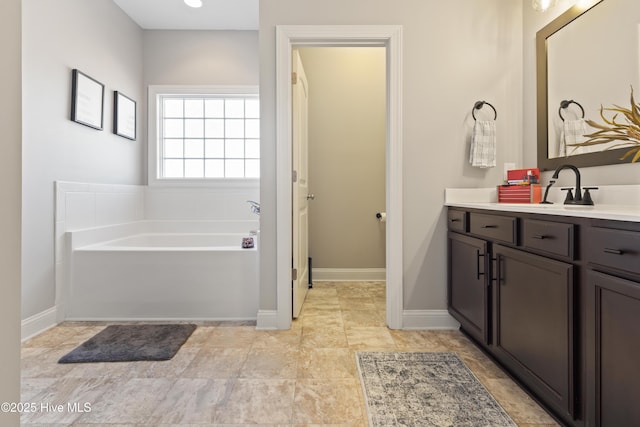 bathroom with vanity and a bath