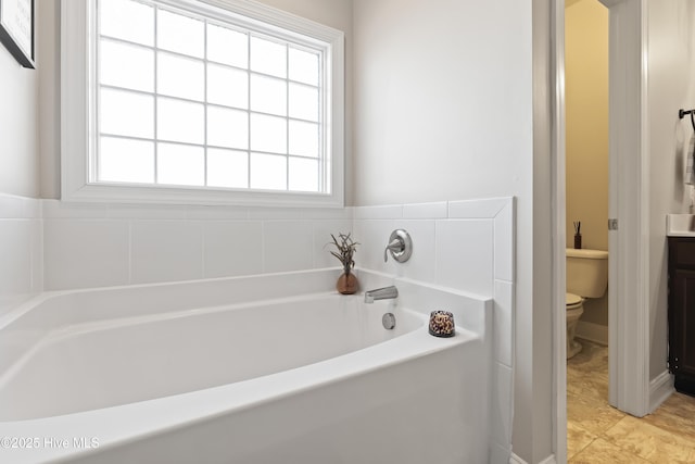 bathroom featuring a healthy amount of sunlight, toilet, and a bathtub