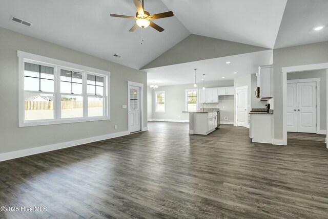 74 Talbert Dr, Rocky Point, NC 28457 - unfurnished living room with sink, ceiling fan with notable chandelier, high vaulted ceiling, and dark wood-type flooring
